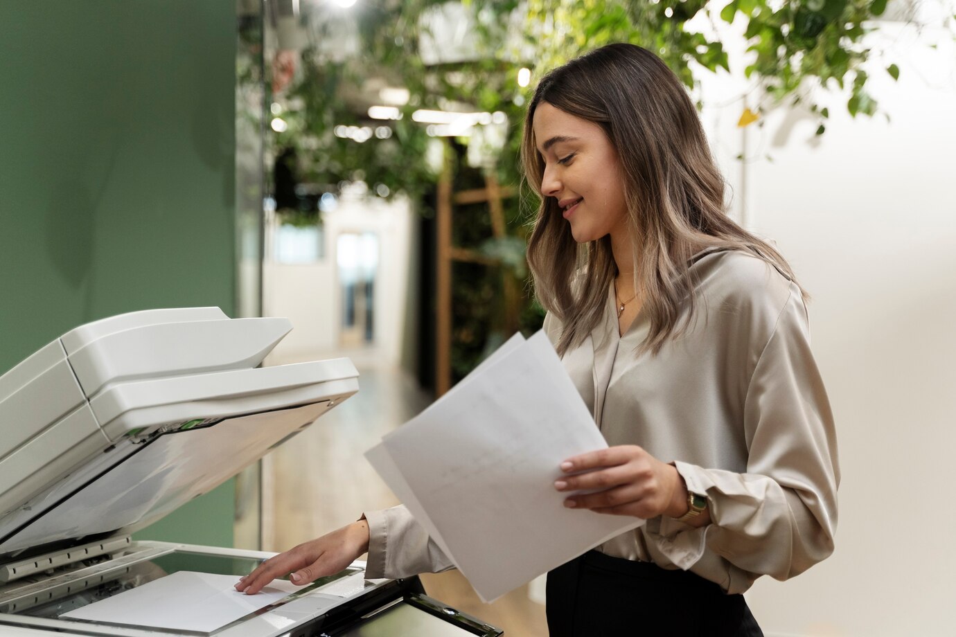 Smiling woman holding printout near Canon printer.