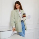 Woman holding coffee cup while browsing Canon Printer Sellers Russia online
